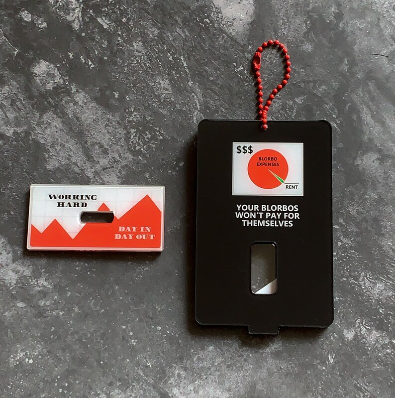 May include: Two black and white motivational cards with red accents. The first card says "Working Hard" and has a red mountain range graphic. The second card says "Your Blorbos Won't Pay For Themselves" and has a pie chart graphic with the words "Blorbo Expenses" and "Rent".