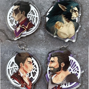 Puede incluir: Cuatro retratos de personajes diferentes impresos en llaveros de acrílico transparente. Cada llavero presenta un personaje diferente con un diseño y una combinación de colores únicos. Los personajes están todos de perfil y tienen un diseño circular a su alrededor.