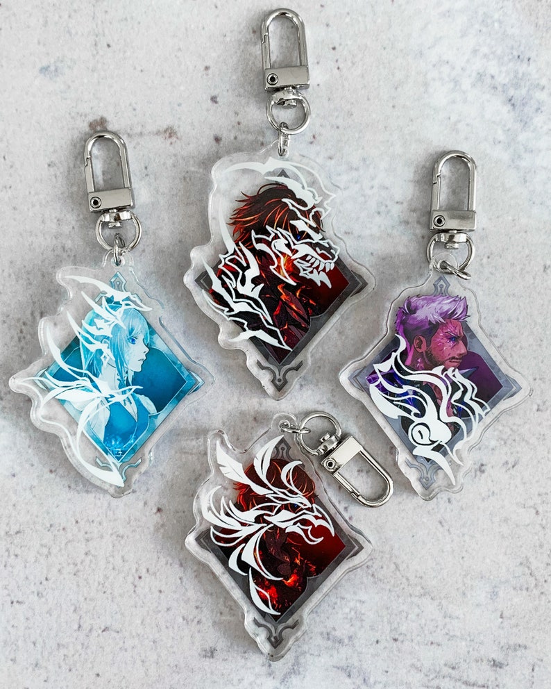 May include: Four clear acrylic keychains featuring different character designs. Each keychain has a white silhouette of a character against a colourful background. The characters include a woman with wings, a man with a beard, a man with horns, and a woman with a crown.