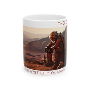 May include: White ceramic mug with a red and white image of an astronaut sitting on a red planet. The text "TESLA" and "THE FIRST CITY ON MARS" is printed on the mug.