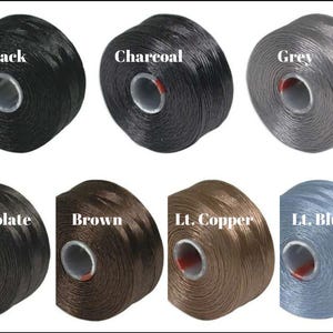 May include: Spools of embroidery floss in various colors, including black, charcoal, grey, chocolate, brown, light copper, and light blue.