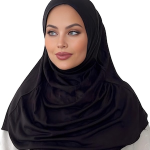 May include: A black jersey hijab with a simple, sleek design. The hijab is made of a soft, stretchy fabric and is perfect for everyday wear.