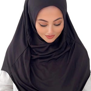 May include: A black jersey hijab with a simple design. The hijab is made of a soft, stretchy fabric and is easy to style.