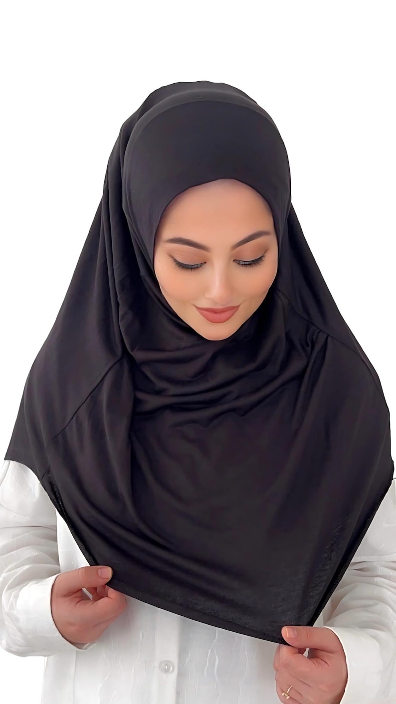 May include: A black jersey hijab with a simple design. The hijab is made of a soft, stretchy fabric and is easy to style.