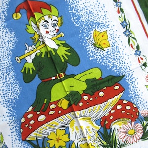 Puede incluir: Un paño de cocina vintage con una ilustración caprichosa de un elfo sentado tocando la flauta sobre una seta roja con lunares blancos. El elfo viste un atuendo verde y un sombrero rojo. También se representa una mariposa amarilla y flores.