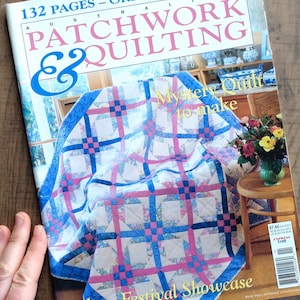 May include: A copy of "Australian Patchwork & Quilting" magazine. The cover features a colourful quilt with a white base, blue borders, and pink and blue squares. The magazine also has the text "Mystery Quilt to make" and "Sydney Festival Showcase".