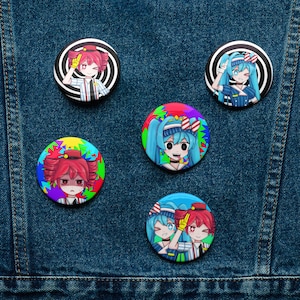 May include: A collection of five colorful anime-style button pins. The pins feature various characters with vibrant hair and clothing, set against swirling and patterned backgrounds. The pins are displayed on a denim background.