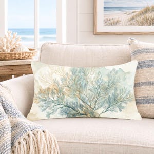 May include: A rectangular throw pillow featuring a watercolour-style illustration of sea fan coral in shades of teal, blue, and soft beige against an off-white background. The design displays intricate, branching coral patterns across the fabric.