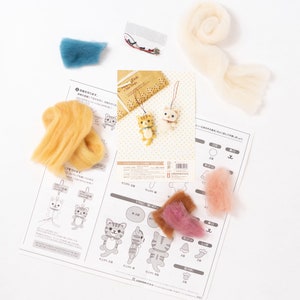 Pu&ograve; includere: Un kit di feltro per realizzare un portachiavi a forma di gatto. Il kit comprende lana di vari colori, un ago e istruzioni. Le istruzioni sono in giapponese. Il kit include anche una piccola busta di plastica con un anello di metallo e un piccolo pezzo di corda.