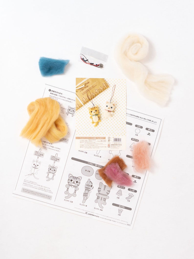 Pu&ograve; includere: Un kit di feltro per realizzare un portachiavi a forma di gatto. Il kit comprende lana di vari colori, un ago e istruzioni. Le istruzioni sono in giapponese. Il kit include anche una piccola busta di plastica con un anello di metallo e un piccolo pezzo di corda.
