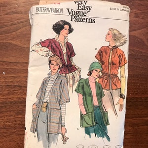 May include: Vogue Patterns sewing pattern showing illustrations of women's tops and jackets. The pattern includes various styles, such as a short-sleeved jacket with pockets and a tie-waist top. The pattern is labelled "very easy."
