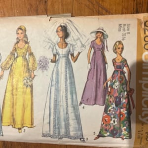 Può includere: Busta di cartamodello Simplicity vintage con illustrazioni di cinque abiti lunghi. Gli abiti sono in vari colori, tra cui bianco, giallo e viola. La busta ha il numero 9260 e la parola "Simplicity".