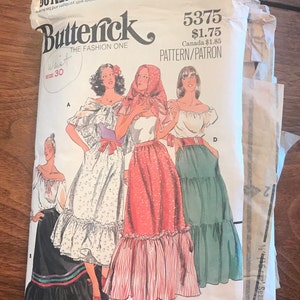 May include: Vintage Butterick sewing pattern, size 30 waist. The pattern features illustrations of women's clothing designs, including dresses and skirts. The cover has the text "THE FASHION ONE" and the pattern number 5375.