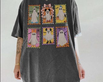 Puede incluir: Una camiseta de manga corta gris carbón con un estampado gráfico de seis diseños de sellos postales rectangulares. Cada sello muestra un personaje de dibujos animados disfrazado de fantasma para Halloween, sosteniendo una calabaza.