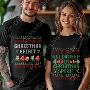 May include: Black t-shirts with Christmas-themed designs. One shirt reads "CHRISTMAS SPIRIT" with ornament graphics. The other shirt says "BALLS DEEP IN CHRISTMAS SPIRIT" with similar ornaments. Both shirts have a festive, sweater-like pattern.