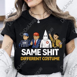 May include: Black t-shirt with a graphic featuring four cartoon figures: an ICE agent, a man in a red "Make America Great Again" hat, a person in a white KKK robe, and a man in a military uniform. The text "SAME SHIT DIFFERENT COSTUME" is displayed.