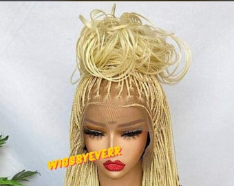 May include: A blonde braided wig with a high bun. The wig is made with small braids and is styled in a long, straight style. The wig is on a mannequin head.