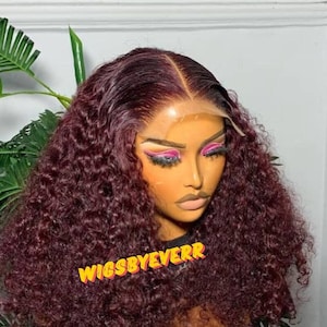 May include: A burgundy curly human hair wig with a lace front. The wig is styled in loose curls and has a natural-looking hairline. The wig is labelled "WIGSBYEVERR".