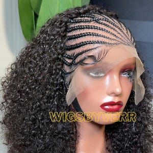 May include: A black curly wig with braided cornrows and a lace front. The wig features a natural-looking hairline and is styled on a mannequin head. The text "WIGSBYVERR" is displayed in gold letters.