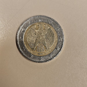 Peut inclure: Une pièce de 1 euro allemande en argent et or avec l'année 2002 imprimée dessus. La pièce représente une image stylisée d'un aigle allemand.