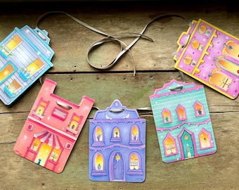 May include: A colorful garland of five houses with different designs and colors. Each house has a unique window and door design. The garland is perfect for a festive occasion.