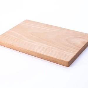 Op de afbeelding: Een rechthoekig houten snijplank gemaakt van licht hout met een natuurlijke houtnerf.
