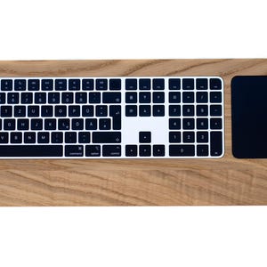Könnte beinhalten: Ein Holz-Tastatur- und Trackpad-Kombination mit einer schwarzen Tastatur- und Trackpad-Oberfläche. Die Tastatur verfügt über einen vollständigen Satz von Tasten, einschließlich Funktionstasten und einen Nummernblock.
