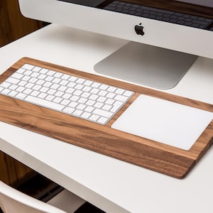 May include: A wooden keyboard and trackpad set. The keyboard and trackpad are white and are set into a dark brown wooden base.