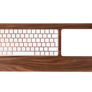 May include: A wooden keyboard and trackpad desk mat with a white keyboard and trackpad. The keyboard has rose gold keys and the trackpad is white.