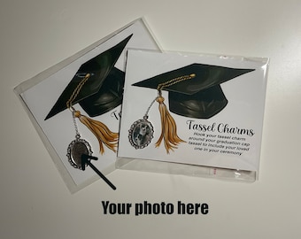 Pode incluir: Encantos de borla com uma ilustração de chapéu de formatura, borla dourada e pingente decorativo. O texto diz "Tassel Charms" e inclui instruções. Embalado em plástico transparente.