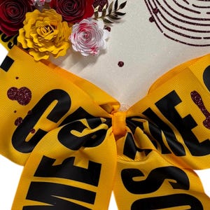 Puede incluir: Un lazo de cinta amarilla con las palabras "ESCENA DEL CRIMEN" en negro, con detalles de purpurina roja. El fondo presenta una superficie blanca con decoraciones florales y el texto "CASO CERRADO".