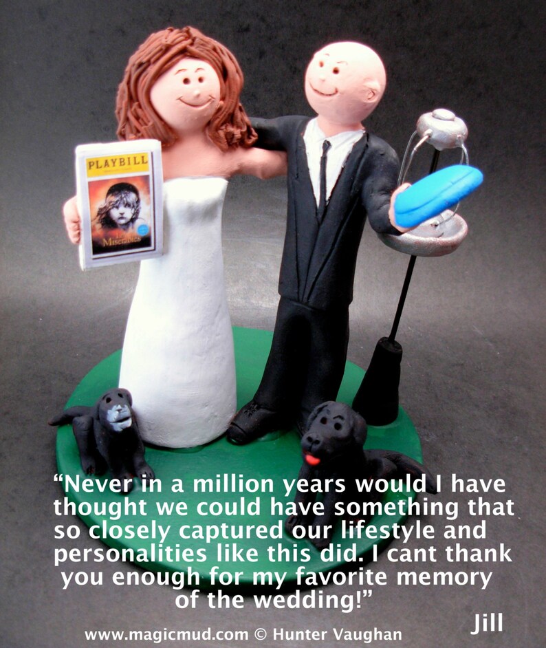 May include: A wedding cake topper featuring a bride and groom in a whimsical style. The bride is holding a Playbill for the musical "The Music Man". The groom is holding a blue frisbee. The cake topper is on a green base with two black dogs.