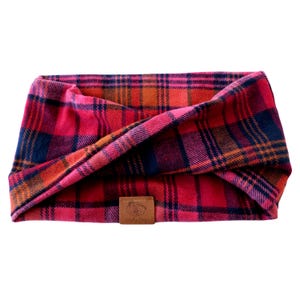 May include: Red, orange, and black plaid dog bandana with a brown leather tag that says "Snuggle Pup".
