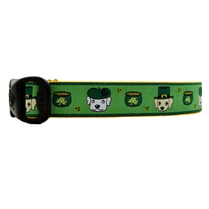 Puede incluir: Collar de perro verde y amarillo con un patrón repetido de perros blancos que llevan sombreros verdes y sostienen ollas de oro.