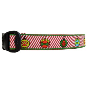 Peut inclure: Collier de chien rayé rouge et blanc avec une bordure verte et des motifs d'ornements de Noël représentant une empreinte de patte, un os, une borne d'incendie et un os.