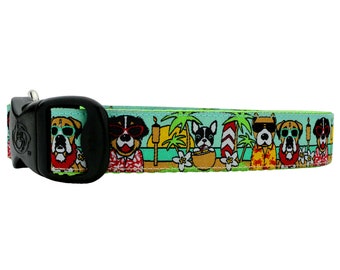 May include: A green, blue, and yellow dog collar with a repeating pattern of dogs wearing sunglasses and Hawaiian shirts on a beach. The collar has a black plastic buckle.