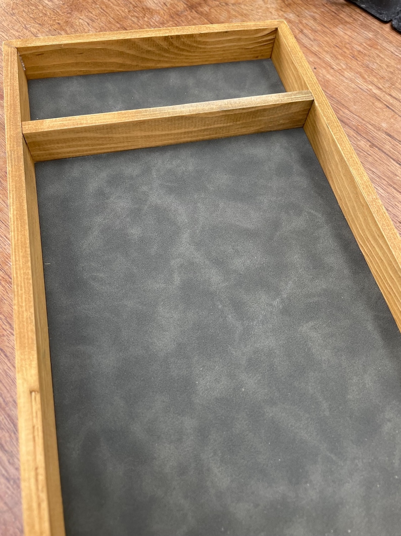 May include: A wooden tray with a gray felt lining and a single divider. The tray is made of natural wood with a light brown finish.