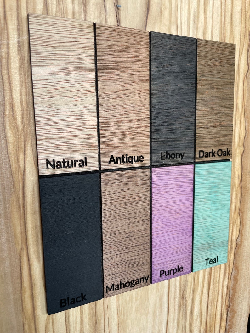 May include: A wood sample board with different wood finishes. The finishes are: Natural, Antique, Ebony, Dark Oak, Black, Mahogany, Purple, and Teal.