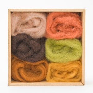 May include: A wooden box filled with five skeins of wool yarn in different colors: beige, orange, green, brown, and yellow.