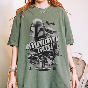 以下が含まれることがあります： スターウォーズシリーズ「マンダロリアンとグローグ」のグラフィックが特徴の緑色のTシャツ。デザインには、マンダロリアンのヘルメット、グローグ、そして「This is the Way」というフレーズが含まれています。