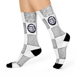 Puede incluir: Calcetines blancos con un patrón de cuadros blanco y negro. Los calcetines presentan un gráfico de una cara de robot con una pantalla para la cabeza.