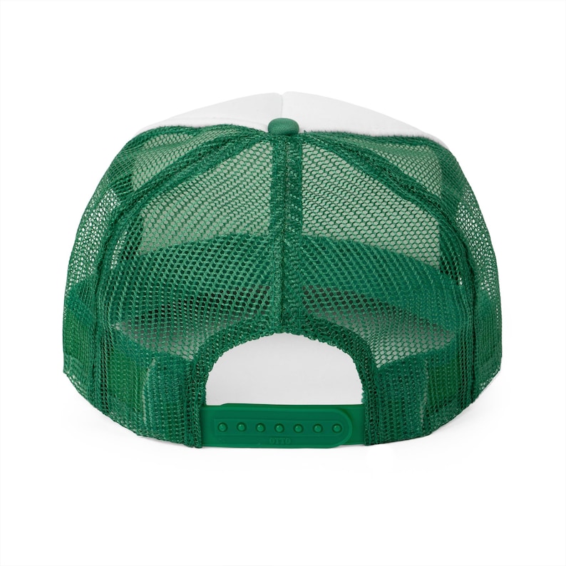 Puede incluir: Gorra de camionero blanca y verde con parte trasera de malla. La gorra tiene una correa ajustable verde.