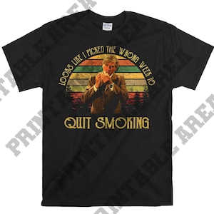May include: A black t-shirt with a vintage-style graphic of a man smoking a cigarette. The graphic includes the text "Looks like I picked the wrong week to quit smoking".