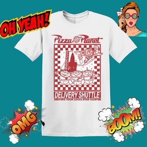 K&ouml;nnte beinhalten: Wei&szlig;es T-Shirt mit einer roten Grafik des Pizza Planet Logos, einer Rakete und drei Alien-Charakteren aus dem Toy Story Film-Franchise. Der Text "Delivery Shuttle" und "Serving Your Local Star Cluster" ist unter der Grafik gedruckt.