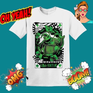 Op de afbeelding: Wit T-shirt met een groene en zwarte afbeelding van een personage uit The Nightmare Before Christmas. De afbeelding is een speelkaart met de tekst "Wheel of Fortune" erop.