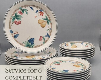 May include: A complete set of dinnerware for six. The plates and bowls have a cream-colored background with a fruit and floral design. The rims are decorated with a brown rope-like pattern and a blue border. The text "Service for 6 COMPLETE SET" is visible.