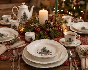 Puede incluir: Un juego de vajilla de porcelana blanca con un patrón de árbol de Navidad verde y bordes festoneados. La colección incluye platos, cuencos, tazas, platillos, una tetera, una lechera y un azucarero sobre un mantel de cuadros rojos y verdes.