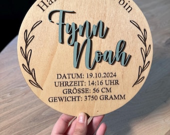 Puede incluir: Un letrero redondo de madera con el texto "Hallo Welt, ich bin Fynn Noah" y la fecha "19.10.2024", la hora "14:16 Uhr", el tamaño "56 cm" y el peso "3750 gramos".