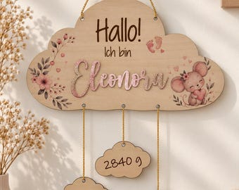 Puede incluir: Un adorno de pared de madera con forma de nube que presenta el texto "Hallo! Ich bin Eleonora" en marrón, un nombre en purpurina rosa, una ilustración de ratón y tres nubes colgantes más pequeñas con los datos 2840 g, 17.06.2025 y 48 cm.
