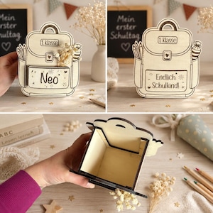 Puede incluir: Caja de madera con forma de mochila, de color marr&oacute;n claro con contornos negros. La caja tiene el texto "Neo" en la parte delantera. La caja est&aacute; decorada con un l&aacute;piz, una regla y un peque&ntilde;o ramo de flores. La tapa es abatible.